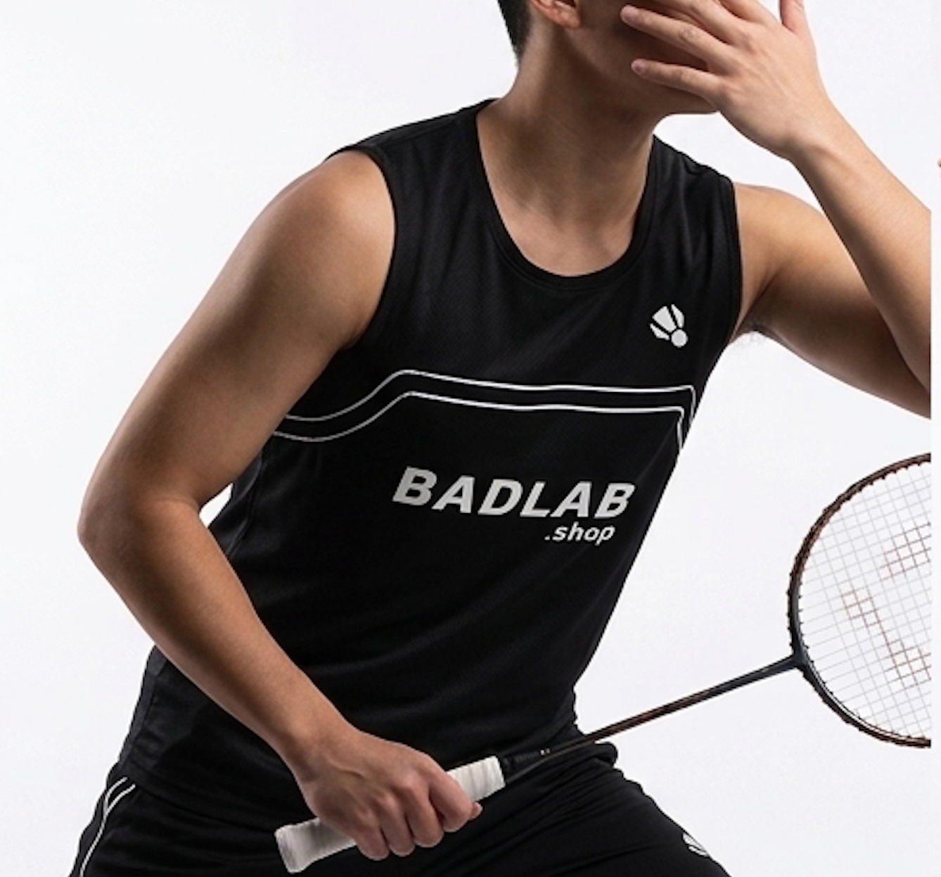 Person wearing a black sleeveless shirt with 'BADLAB' branding, holding a badminton racket.